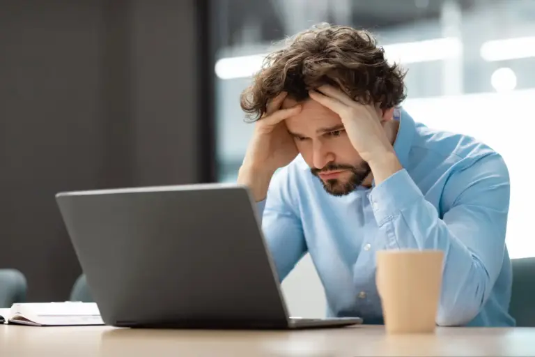 Sad business man grabbing head using laptop