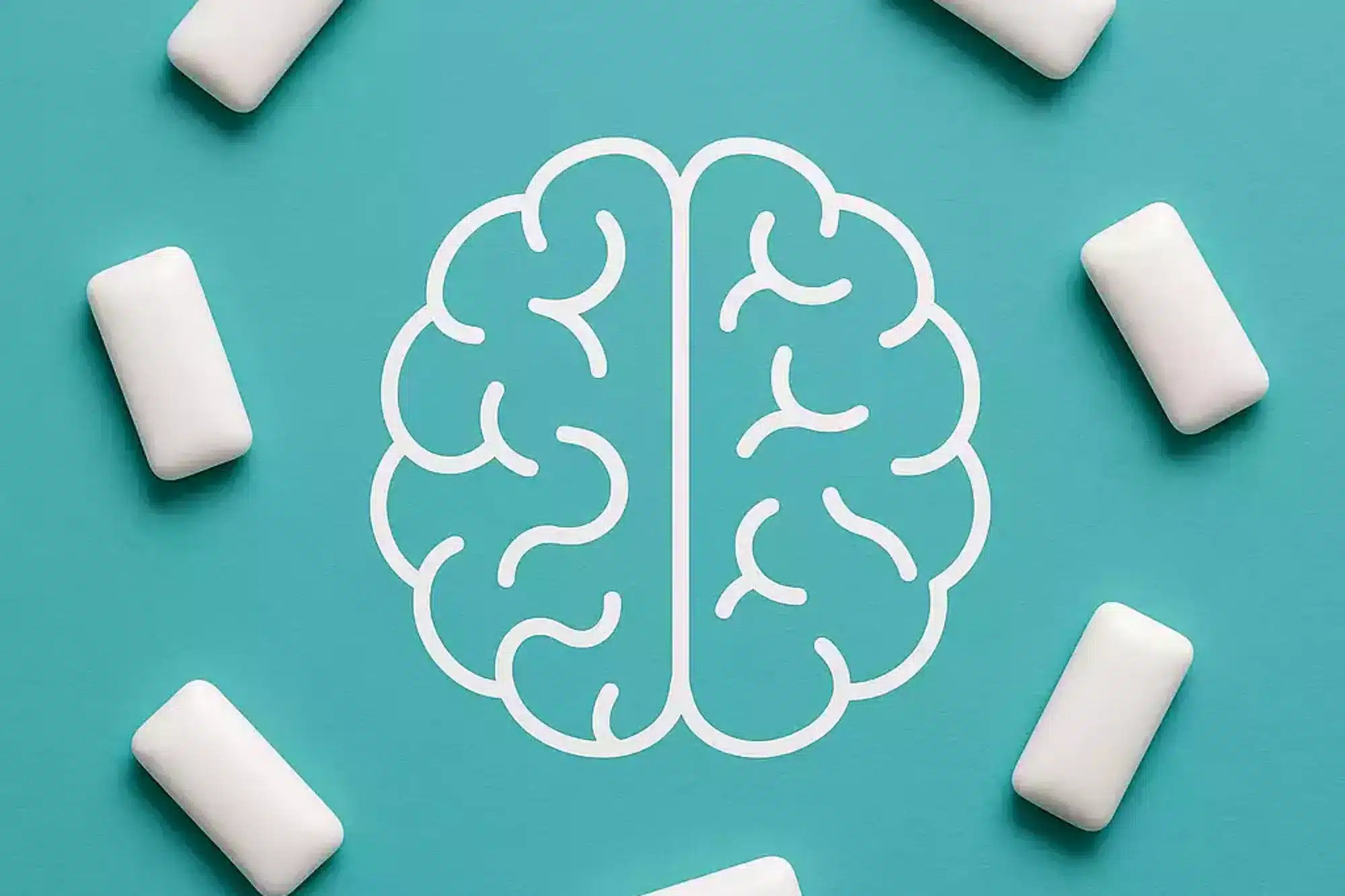 Kaugummi und Gehirn – weiße Kaugummis im Kreis um ein Gehirn-Symbol zur Konzentrationssteigerung